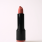 ‘Bombshell’ soft matte lipstick, a pinky nude shade, standing open in a black tube on a light pink background