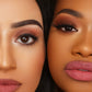 Two models, one with a light-medium skin tone and one with a deep skin tone, side by side in close-up, both wearing a matte mauve-pink lipstick