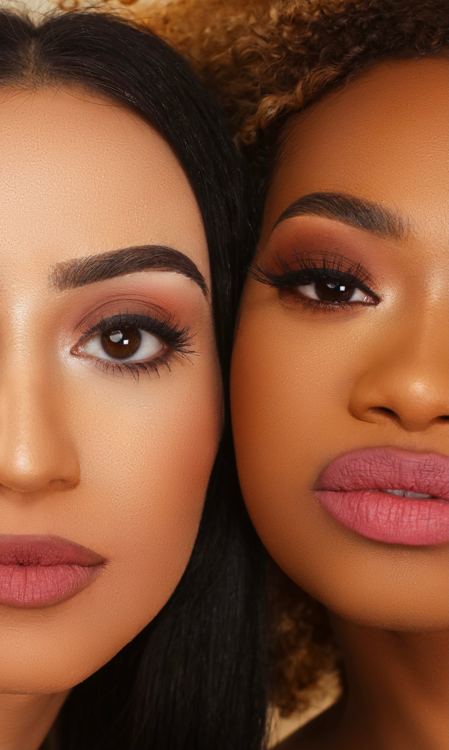 Two models, one with a light-medium skin tone and one with a deep skin tone, side by side in close-up, both wearing a matte mauve-pink lipstick